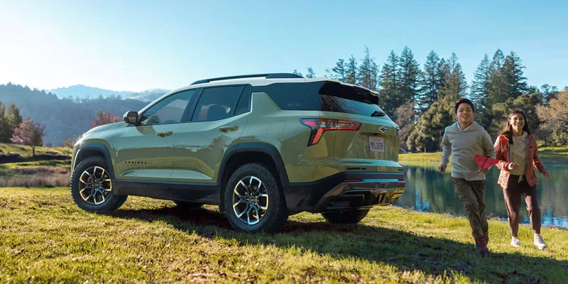 Two children running behind a 2025 Chevy Equinox near Clinton Township, MI