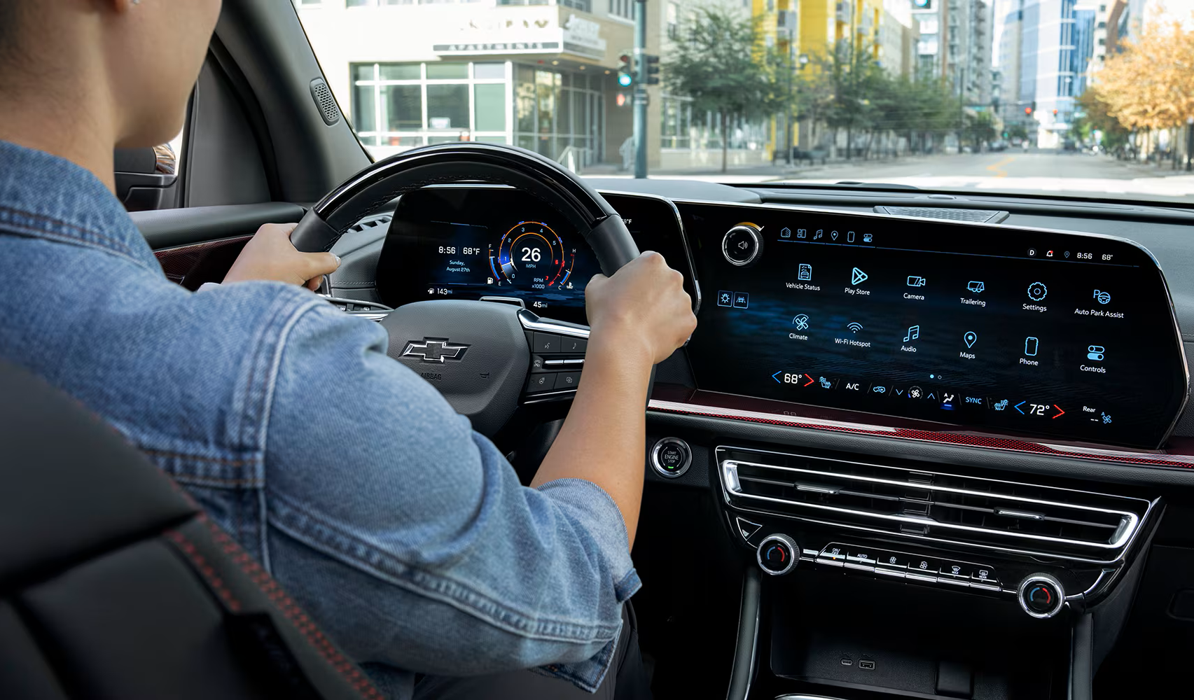 Man behind the wheel of a Chevy Traverse, and a view of dashboard and tech interface